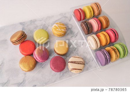 Top view of french macarons gift box macaroons wrapped in giftbox on marble board tabletop. Colorful selection of pastries Top view of french macarons gift box macaroons wrapped in giftbox on marble board tabletop. Colorful selection of pastries 78780365