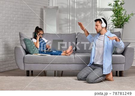 daughter learns using laptop and playful happy father dancing daughter learns using laptop and playful happy father dancing 78781249