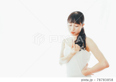 部屋でヘアケアをする若い女性 部屋でヘアケアをする若い女性 78783858