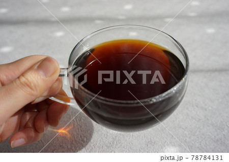 ガラスのカップに入れたコーヒーを持つ 78784131