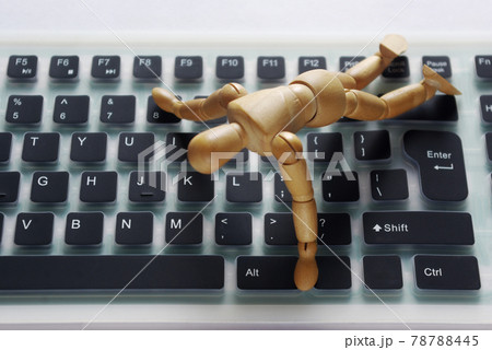 シリコンキーボードの上で跪く木製のモデル人形 78788445
