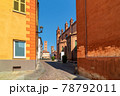 Cobblestone street and medieval towers on background in old historic center of Alba, Italy. 78792011
