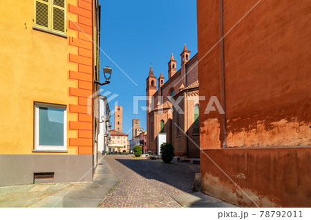Cobblestone street and medieval towers on background in old historic center of Alba, Italy. 78792011