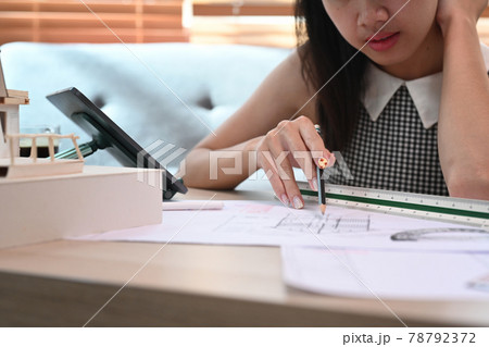 Architect woman working with a blueprint in living room. 78792372
