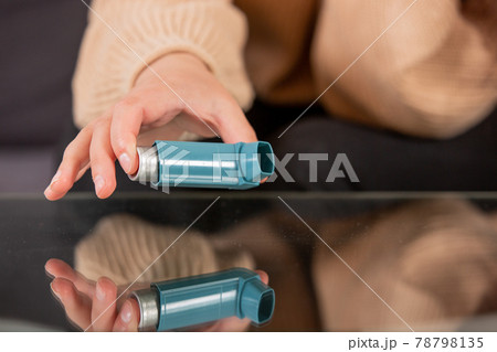 Young woman looking for an asthma inhaler during strong asthma attack, cannot breathing, healthcare concept 78798135