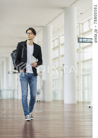 ノートパソコンとバックパックを持って歩く30代の男性 78800561