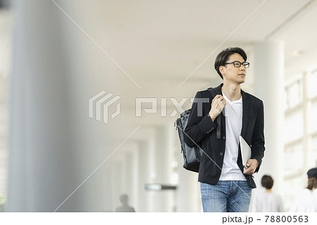 ノートパソコンとバックパックを持って歩く30代の男性 78800563