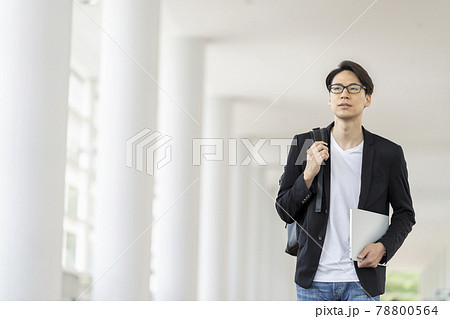 ノートパソコンとバックパックを持って歩く30代の男性 ノートパソコンとバックパックを持って歩く30代の男性 78800564