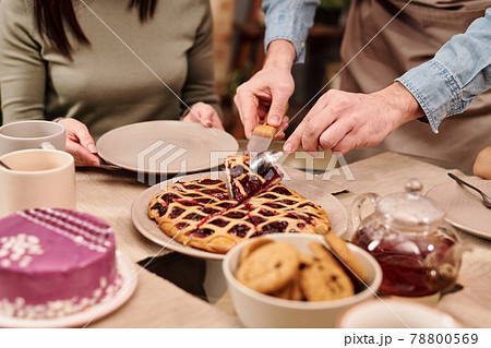 Young man taking piece of fresh homemade berry cake Young man taking piece of fresh homemade berry cake 78800569