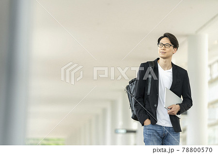 ノートパソコンとバックパックを持って歩く30代の男性 ノートパソコンとバックパックを持って歩く30代の男性 78800570