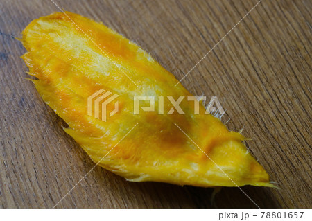 A long bone from a mango lies on the table. 78801657