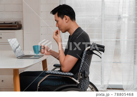 An Asian disabled man sits in a wheelchair is stressed and disappointed And taking medicine After having a car accident, The concept of negligence and the effects of drunk driving. 78805468