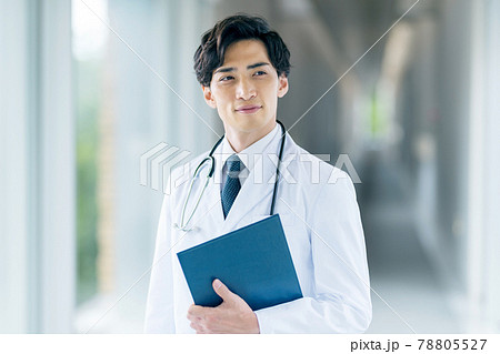 病院の廊下に立つ白衣の若い男性医師 病院の廊下に立つ白衣の若い男性医師 78805527