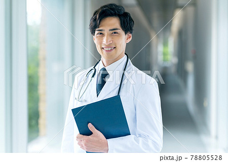 病院の廊下に立つ白衣の若い男性医師 病院の廊下に立つ白衣の若い男性医師 78805528