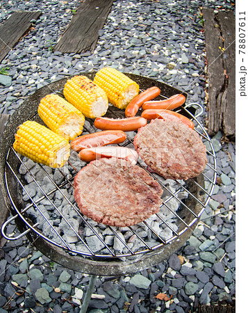 バーベキューセットの炭で焼くトウモロコシとソーセージとハンバーグ 78807611