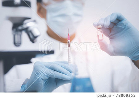 Doctor or scientist with a stethoscope holding COVID-19 vaccine, measles, coronavirus vaccine shot for diseases outbreak vaccination, vaccine Concept fight against virus covid-19 corona virus 78809355