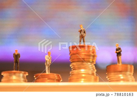 積んだコインと4人のミニチュアのビジネスマン_紫色などのグラデーション背景 78810163