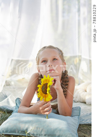 Little girl in white chiffon tent with sunflower 78810229