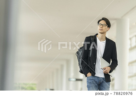 ノートパソコンとバックパックを持って歩く30代の男性 ノートパソコンとバックパックを持って歩く30代の男性 78820976
