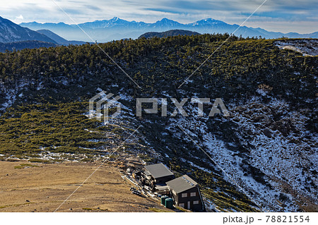 八ヶ岳連峰・根石岳からみる根石山荘と箕冠山・南アルプスの山並み 78821554