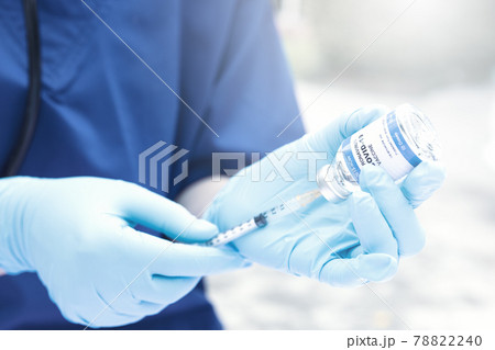 Female doctor with a stethoscope on shoulder holding syringe and COVID-19 vaccine. Healthcare And Medical concept. 78822240