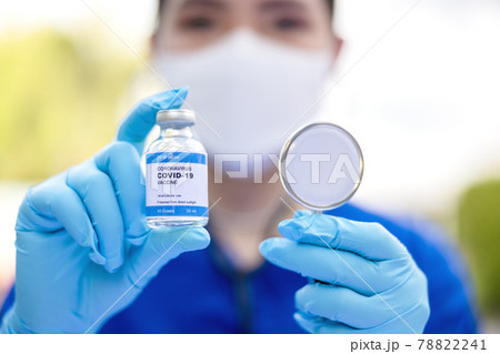 Female doctor with a stethoscope on shoulder holding syringe and COVID-19 vaccine. Healthcare And Medical concept. Female doctor with a stethoscope on shoulder holding syringe and COVID-19 vaccine. Healthcare And Medical concept. 78822241