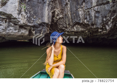 Woman tourist in boat on the lake Tam Coc, Ninh Binh, Viet nam. It's is UNESCO World Heritage Site, renowned for its boat cave tours. It's Halong Bay on land of Vietnam. Vietnam reopens borders after 78822754