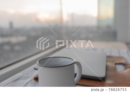 Laptop and white coffee cup with city view. Concept of work from home. Laptop and white coffee cup with city view. Concept of work from home. 78826755