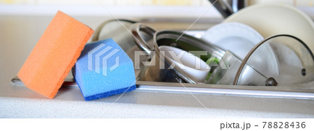 A few sponges lie on the background of the sink with dirty dishes 78828436