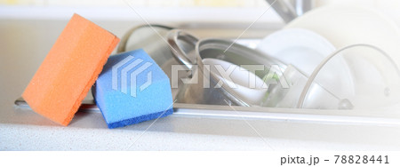 A few sponges lie on the background of the sink with dirty dishes 78828441