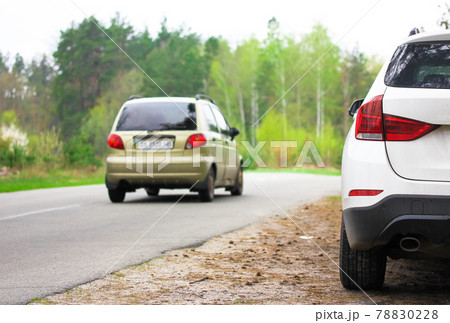 White SUV parked on a roadside in beautiful spring forest. Travel concept. White SUV parked on a roadside in beautiful spring forest. Travel concept. 78830228