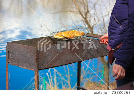 Unrecognizable woman preparing barbecue sandwiches on a grill. Cooking on nature 78830263