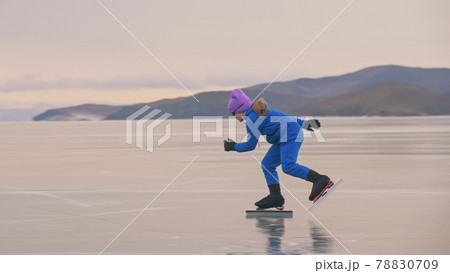 The girl train on ice speed skating. The child skates in the winter in blue sportswear suit, sport glasses. Children speed skating sport. The girl train on ice speed skating. The child skates in the winter in blue sportswear suit, sport glasses. Children speed skating sport. 78830709