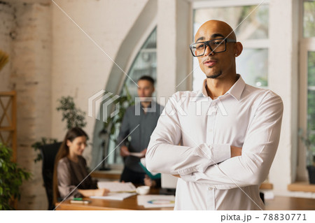 Young African man, office worker, manager working at office with colleagues, Concept of coworking, work days, sales, ad. Young African man, office worker, manager working at office with colleagues, Concept of coworking, work days, sales, ad. 78830771