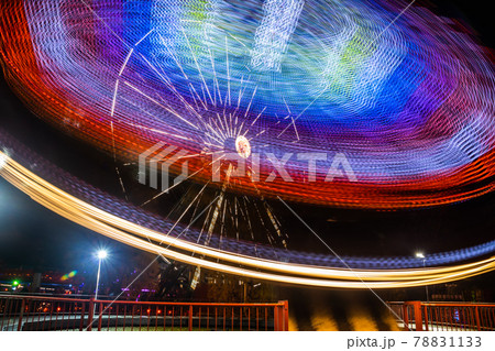 Two rides in motion in amusement park, night illumination. Long exposure. 78831133