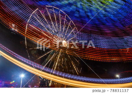 Two rides in motion in amusement park, night illumination. Long exposure. Two rides in motion in amusement park, night illumination. Long exposure. 78831137
