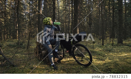 The woman travel on mixed terrain cycle touring with bike bikepacking. The traveler journey with bicycle bags. Magic forest park. The woman travel on mixed terrain cycle touring with bike bikepacking. The traveler journey with bicycle bags. Magic forest park. 78832315