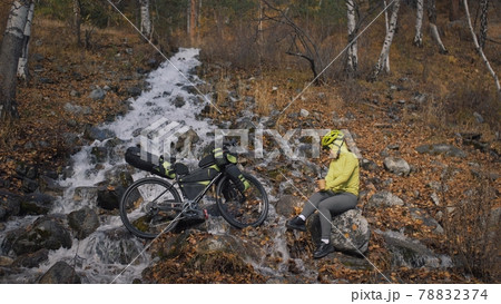 The woman travel on mixed terrain cycle touring with bikepacking. The traveler journey with bicycle bags. Sport tourism bikepacking. The woman travel on mixed terrain cycle touring with bikepacking. The traveler journey with bicycle bags. Sport tourism bikepacking. 78832374