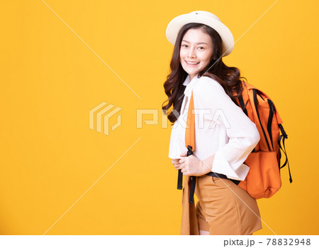 Asian woman traveler with backpack and summer hat smiling on yellow background,Happiness Young Woman Tourist ready to travel standing with copy space,Summer Travel Concept 78832948
