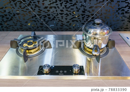 Modern kitchen furniture with contemporary kitchenware like hood, black induction stove and oven in house. Modern kitchen furniture with contemporary kitchenware like hood, black induction stove and oven in house. 78833390