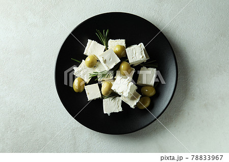Plate with feta cheese, olives and rosemary on white textured background Plate with feta cheese, olives and rosemary on white textured background 78833967