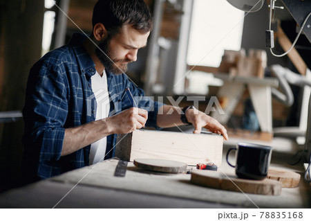 Man in the workshop with a wood Man in the workshop with a wood 78835168