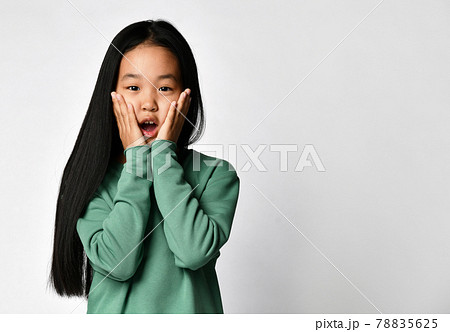 Shocked surprised asian preteen girl in green 78835625