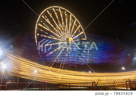 Ferris wheel in motion at the amusement park, night illumination. Long exposure Ferris wheel in motion at the amusement park, night illumination. Long exposure 78835829