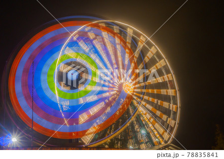 Ferris wheel in motion at the amusement park, night illumination. Long exposure 78835841