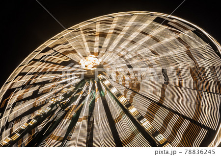 Ferris wheel in motion at the amusement park, night illumination. Long exposure 78836245