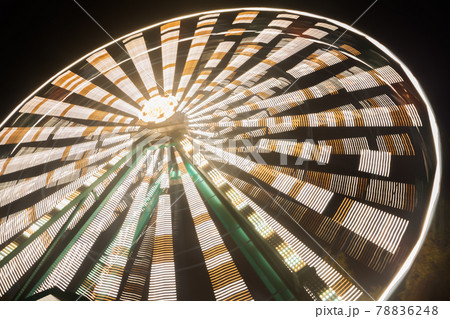 Ferris wheel in motion at the amusement park, night illumination. Long exposure 78836248