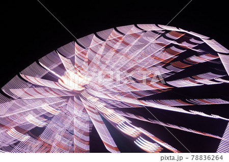 Ferris wheel in motion at the amusement park, night illumination. Long exposure Ferris wheel in motion at the amusement park, night illumination. Long exposure 78836264