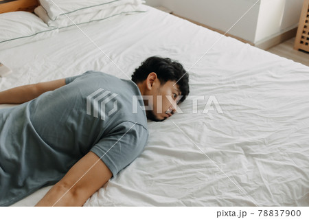 Tired man is lying on the bed as he out of energy. Tired man is lying on the bed as he out of energy. 78837900