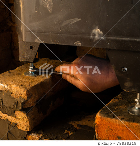 Installing a fireplace with a water furnace in the house, details close up. Installing a fireplace with a water furnace in the house, details close up. 78838219